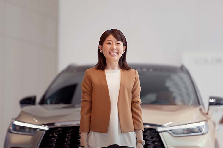 Sayuri Nakashima standing in front of of car smiling for camera