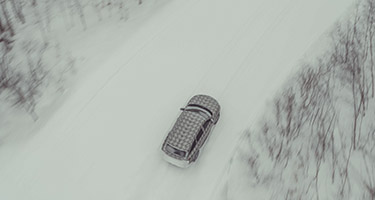 Overhead view of the INFINITI QX60 driving throught the snow.